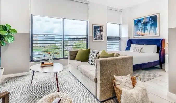 Lit et canapé dans un appartement doté de baies vitrées de l'appart'hôtel Sentral Wynwood à Wynwood, Miami
