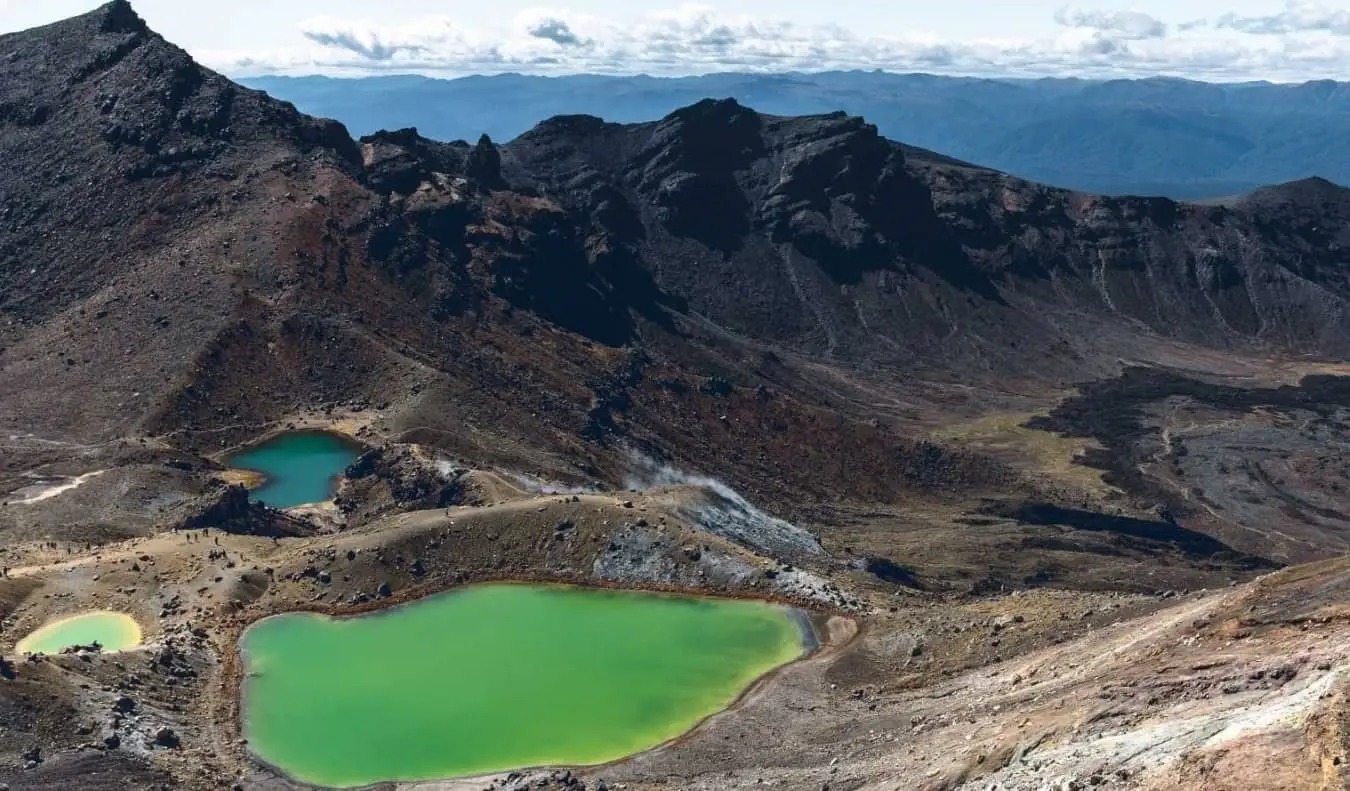 ニュージーランドのハイキング、トンガリロ・アルパイン・クロッシングの荒涼とした火山の風景を背景にしたエメラルドグリーンの湖