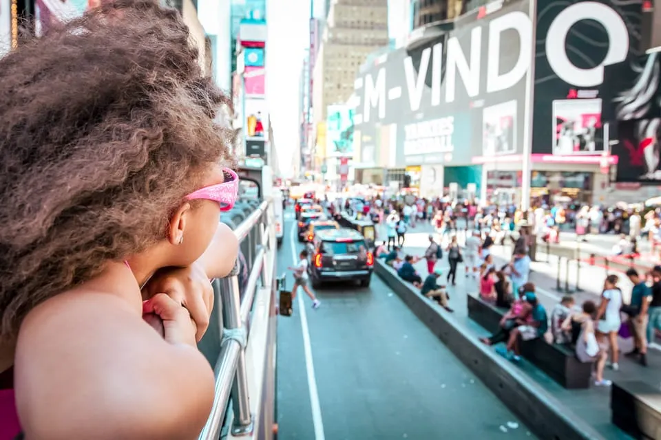 une fille regardant Times Square à New York, conseils de voyage' title=