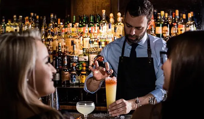 Barman podává luxusní koktejly patronům v Death and Company v NYC