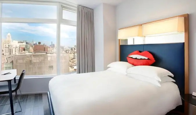 Une chambre d'hôtel avec un oreiller en forme de lèvres sur le lit queen d'un blanc éclatant de l'hôtel Standard à New York
