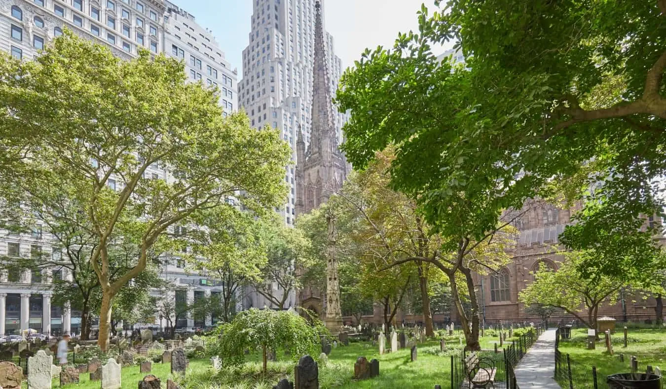 Vieilles tombes dans un cimetière verdoyant entouré d'arbres à l'église Trinity à New York, États-Unis