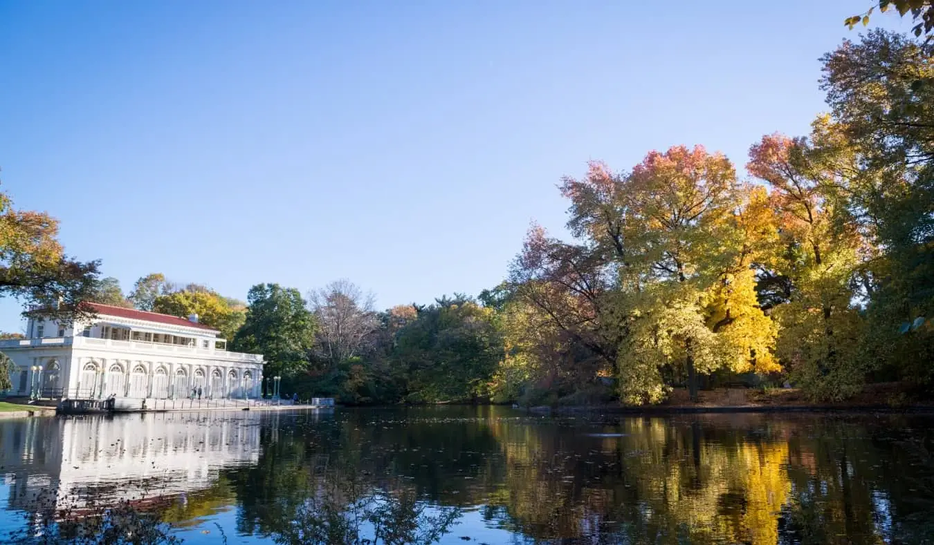 As águas calmas do Prospect Park refletindo um dos edifícios antigos do Brooklyn, Nova York, EUA
