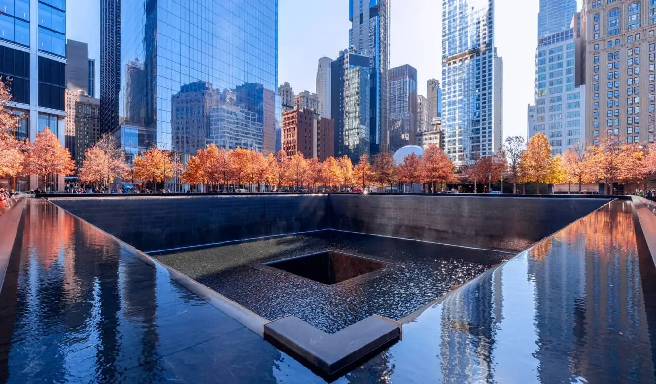 O elemento aquático do Memorial do 11 de Setembro cercado por árvores na cidade de Nova York