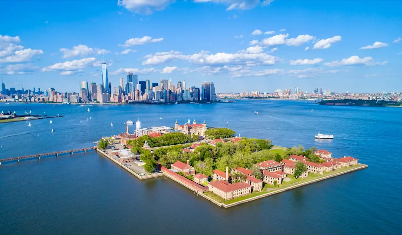 La célèbre Ellis Island vue d'en haut avec New York en arrière-plan lors d'une journée ensoleillée avec un ciel bleu