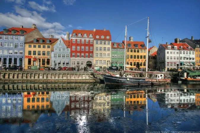 Foto de casas refletidas no porto de Nyhavn, em Copenhague, Dinamarca