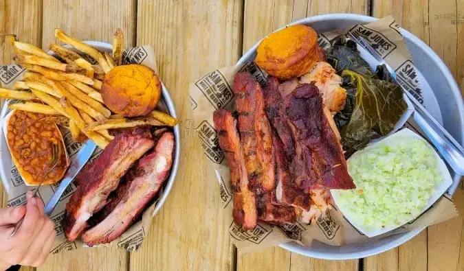 Uma visão aérea de dois pratos cheios de churrasco com acompanhamentos ao estilo sulista em Raleigh, Carolina do Norte