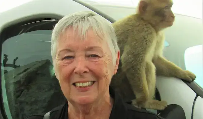 Viajante sênior Sherrill com um macaco no ombro em uma viagem ao exterior
