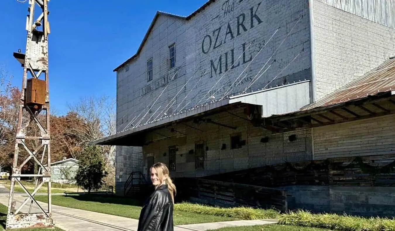 Rejseblogger Raimee Iacofano poserer nær en gammel landbrugsbygning på en Route 66 roadtrip i Missouri