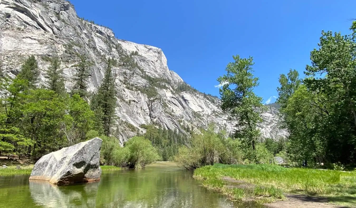 Uma montanha escarpada com um riacho correndo em frente no Parque Nacional de Yosemite, Califórnia