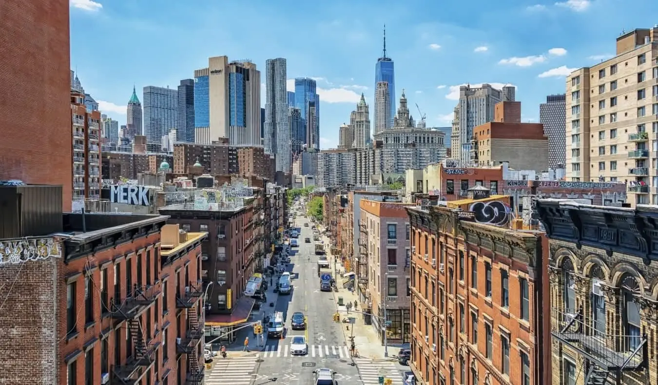 Cidade de Nova York vista da ponte de Manhattan, com prédios residenciais em primeiro plano e arranha-céus modernos ao fundo