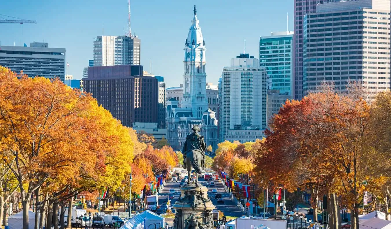 Vista da Benjamin Franklin Parkway repleta de árvores com folhas de laranja na Filadélfia, Pensilvânia