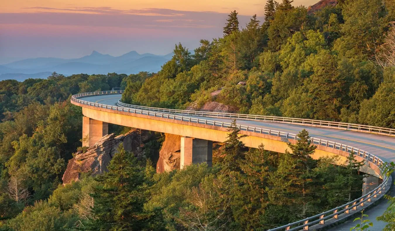 A sinuosa Blue Ridge Parkway cercada por florestas e montanhas, perto de Asheville, Carolina do Norte
