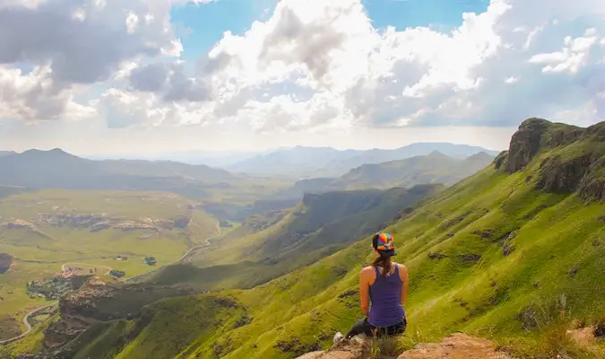 Kristin Addis, voyageuse seule, assise au sommet d'une montagne, regardant la vue