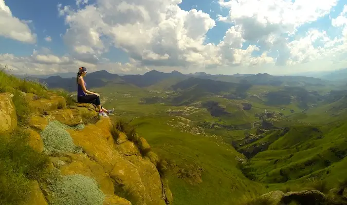 Kristin est ma muse de voyage, assise sur le rebord d'une montagne en Afrique du Sud, pensant