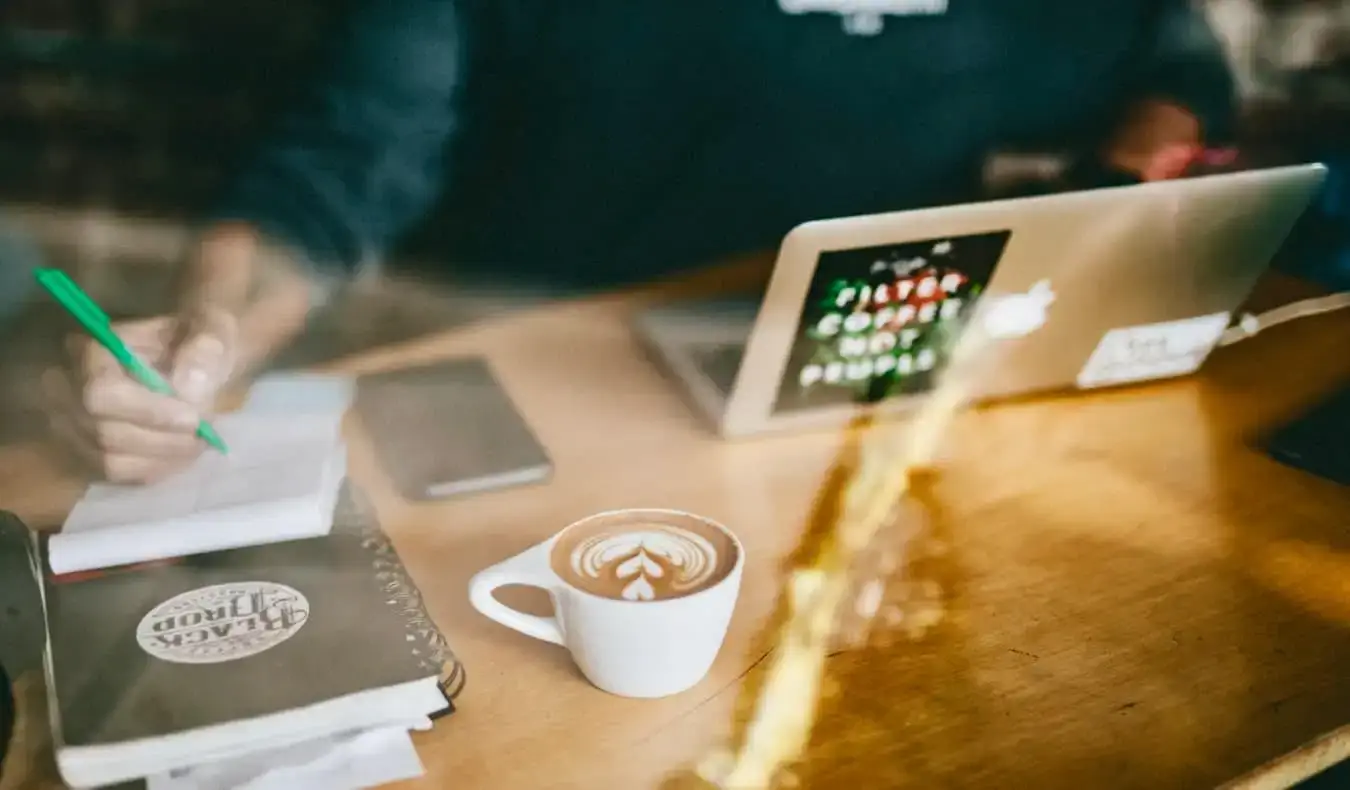 En mann som jobber online på en kafé mens han drikker en latte